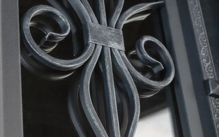 элементы ковки в защитной решетке входной двери со стеклом